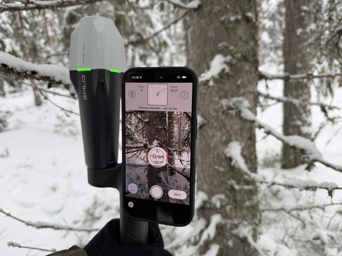 Emlid Reach RX RTK-GNSS receiver alongside a phone running Arboreal Forest